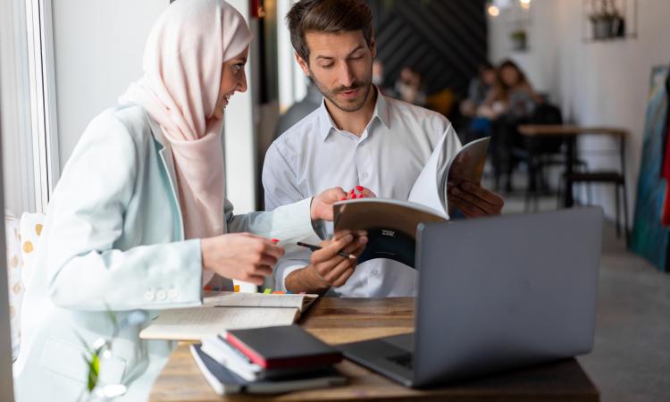 three people sitting at a table working collaboratively