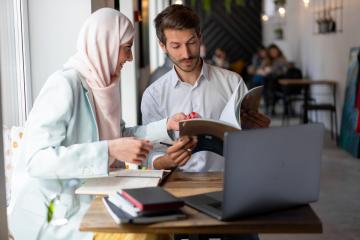 three people sitting at a table working collaboratively