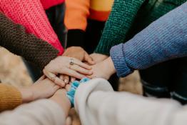 Hands of all different skin colours meeting in a circle