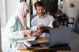 three people sitting at a table working collaboratively